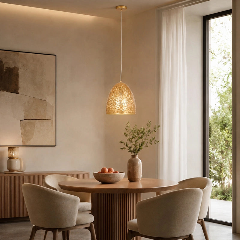 Small gold pendant light hanging above round dining table in modern room