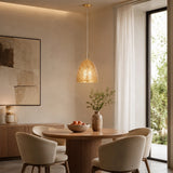 Small gold pendant light hanging above round dining table in modern room