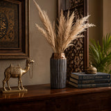 Small grey decorative vase with tall dried pampas grass styled on a wooden console table