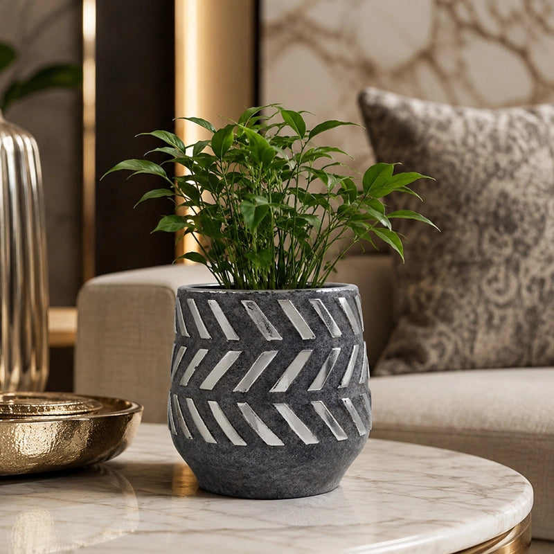 Small grey geometric planter with a green plant on a marble floor in a modern bathroom