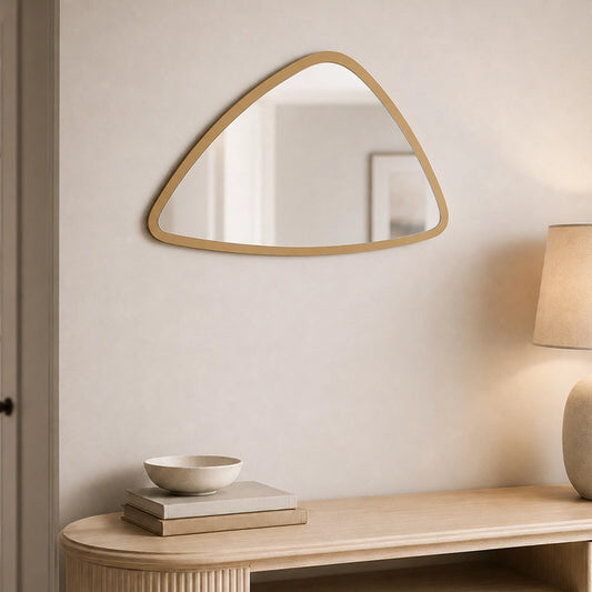 Small triangular wall mirror with gold frame above bathroom shelf