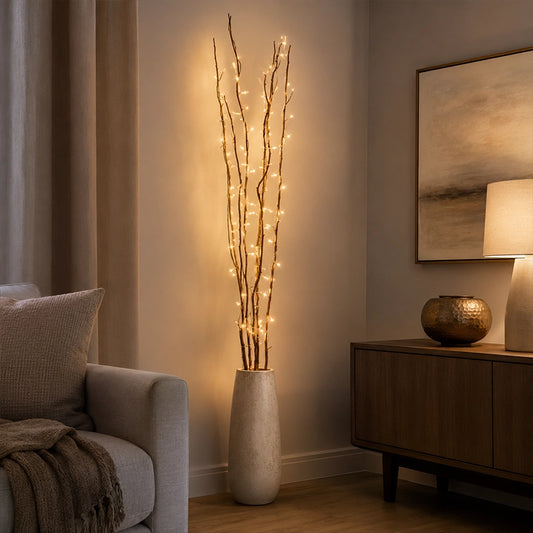 Warm twig lights in tall vase beside sofa in modern living room