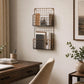 Black wire wall magazine rack with wooden shelves above office desk