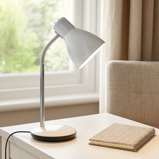 White desk lamp on bedside table with notebook beside window