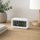 White digital clock on wooden side table beside neutral sofa