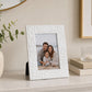 White picture frame with textured pattern displaying family photograph