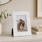 White picture frame with textured pattern displaying family photograph