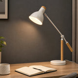 White adjustable table lamp with warm light on wooden desk