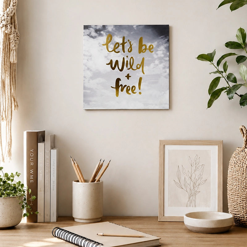 Wooden motivational quote wall plaque with “Let’s Be Wild & Free” lettering displayed above a home office desk