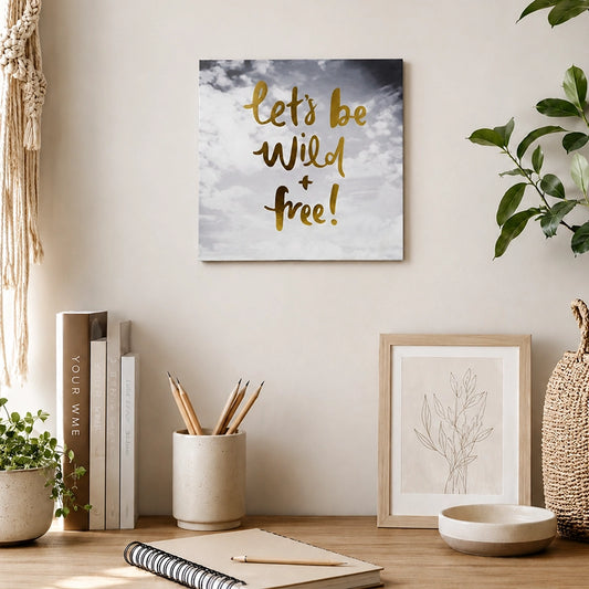 Wooden motivational quote wall plaque with “Let’s Be Wild & Free” lettering displayed above a home office desk