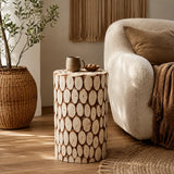 Round side table with natural wood slice pattern beside cream armchair