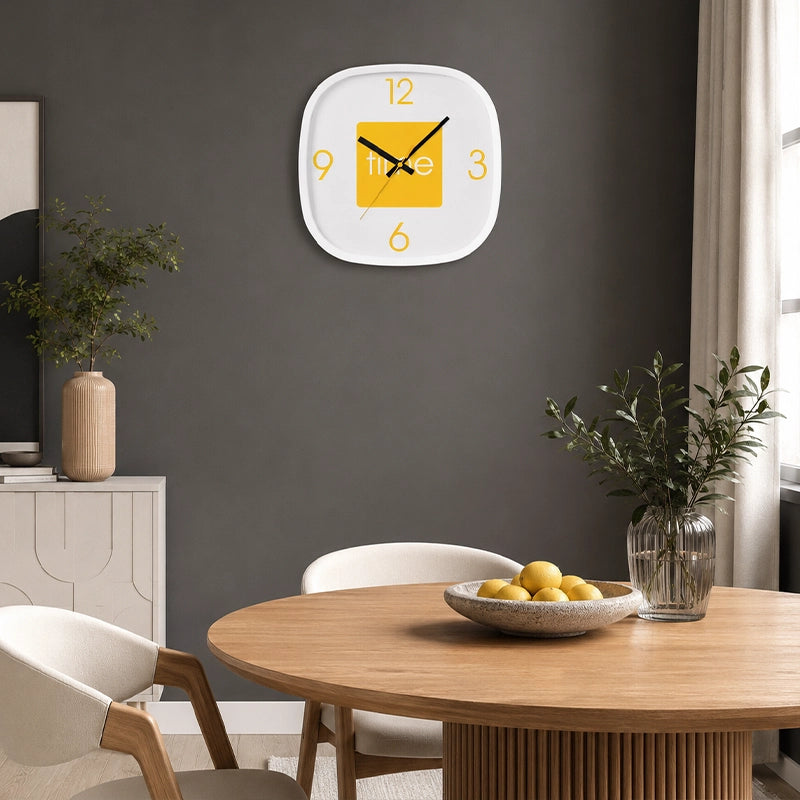 Yellow wall clock above dining table with chairs and dark feature wall