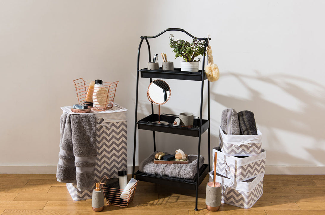Bathroom accessories with black storage rack, laundry baskets, towels, vanity mirror and toiletry organizers