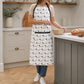 woman wearing black and white kitchen apron with dog print while mixing in bowl, novelty dog design cotton apron for women