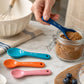 Ceramic measuring spoons set of 4 scooping brown sugar on marble surface