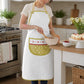 woman wearing cotton kitchen apron while baking, white apron with green trim and decorative floral polka dot pocket