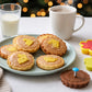 Plate of baked cookies stamped with flower and rabbit designs beside a glass of milk