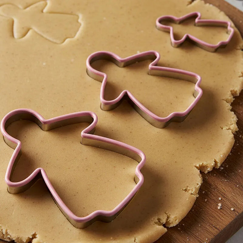Gingerbread lady 3 piece cookie cutter set in three sizes on rolled gingerbread dough