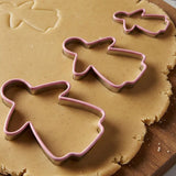 Gingerbread lady 3 piece cookie cutter set in three sizes on rolled gingerbread dough