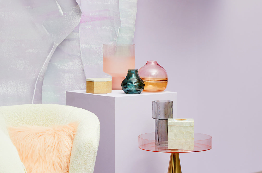 Stylish Home decor accessories with colourful glass vases, decorative boxes and modern accent pieces in a pastel interior