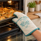 Country Kitchen single oven mitt in cream with teal trim used to take bread out of the oven