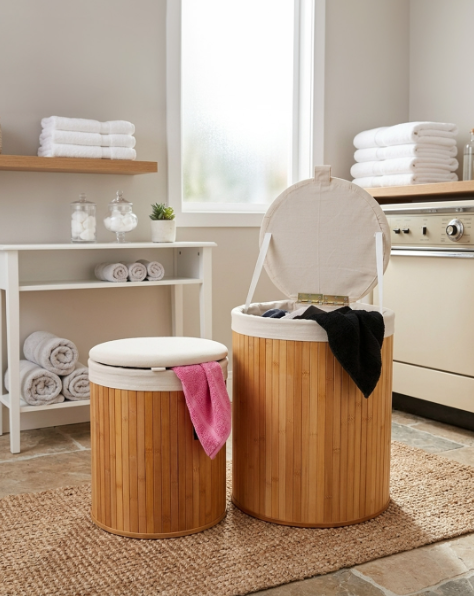 Bamboo laundry baskets with lids and towels in a modern bathroom setting