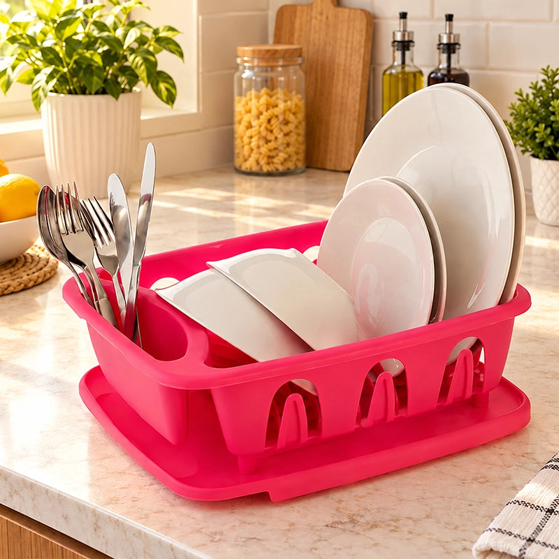 Pink dish drainer with white plates and cutlery on a marble kitchen counter