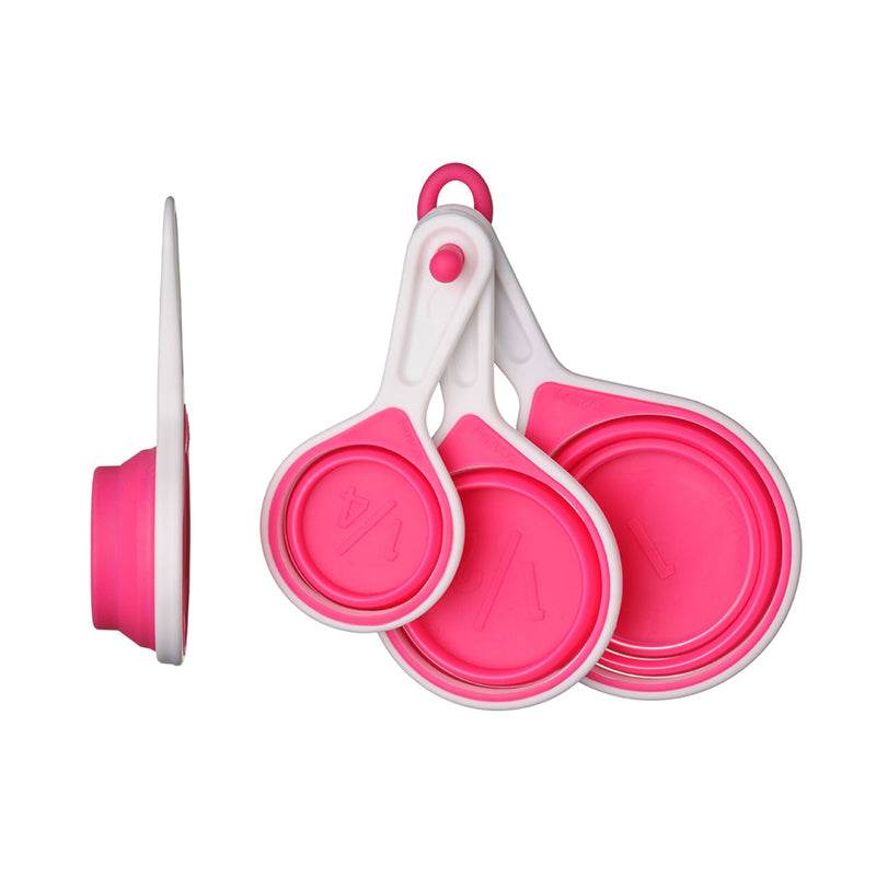 Pink measuring cups set of 4 collapsed and folded on white background