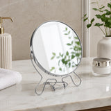 Small silver shaving mirror with round frame on bathroom counter