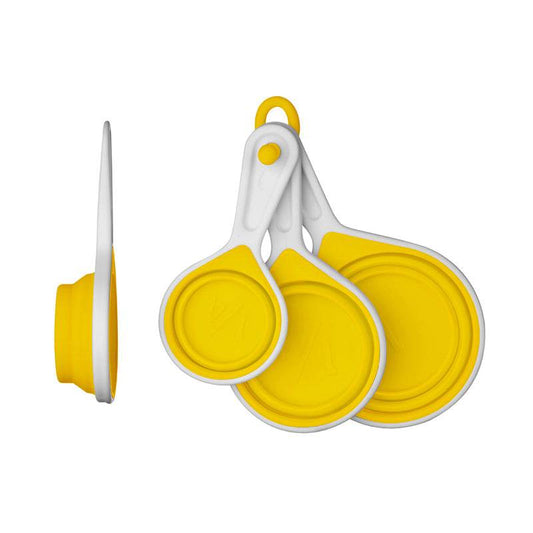 Silicone measuring cups set of 4 in yellow collapsed on white background